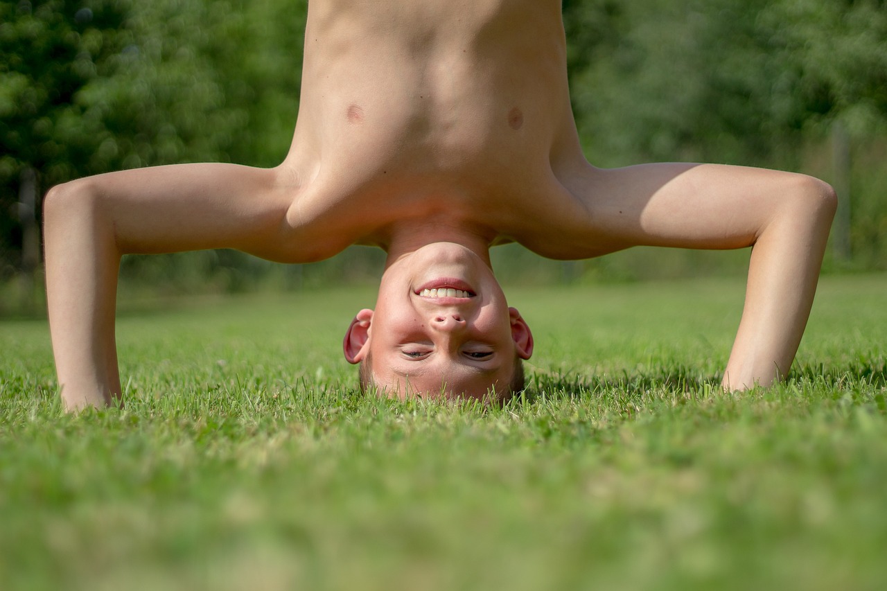 boy nature game child standing on your head luck summer exercises gymnastics childhood carefree holiday joy